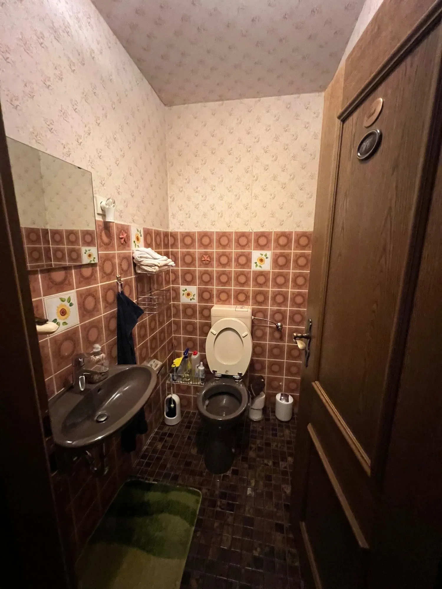 Gäste-WC vor der Sanierung mit alten gemusterten Wandfliesen