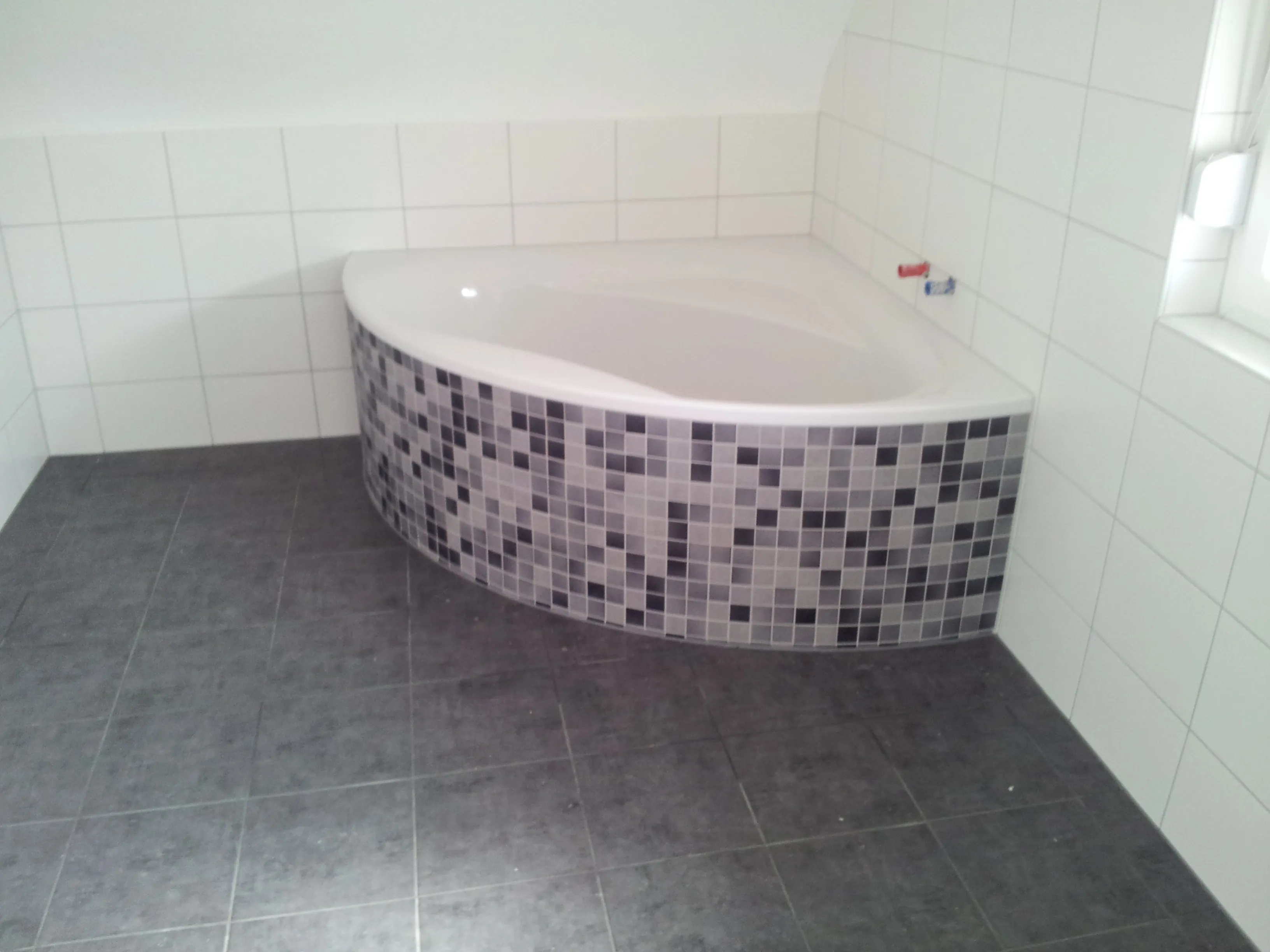 Komplett gefliestes Badezimmer mit ruhiger, heller Flächenwirkung