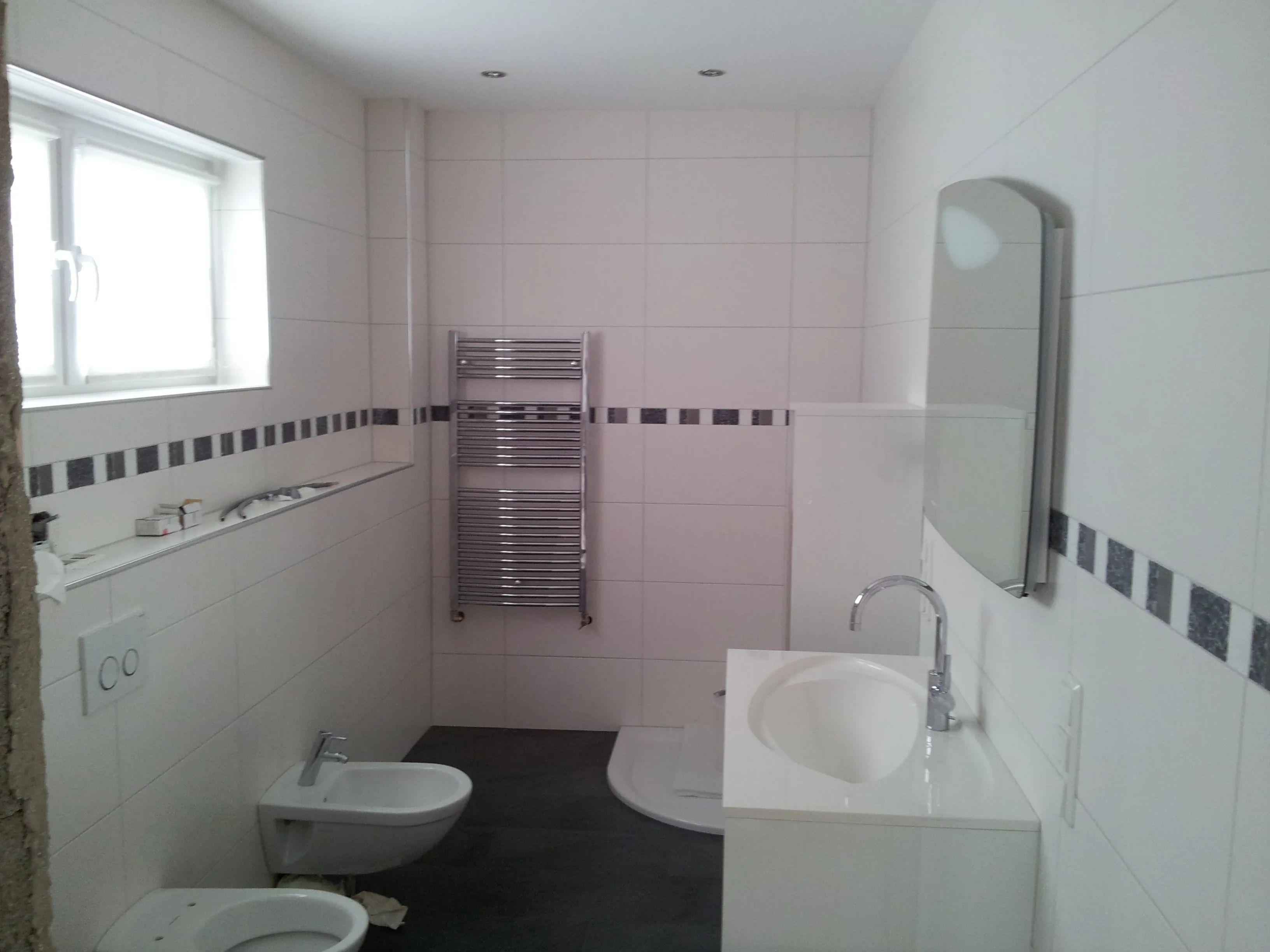 Badezimmer mit gefliestem WC-Bereich, Boden und Wand aus einem Guss