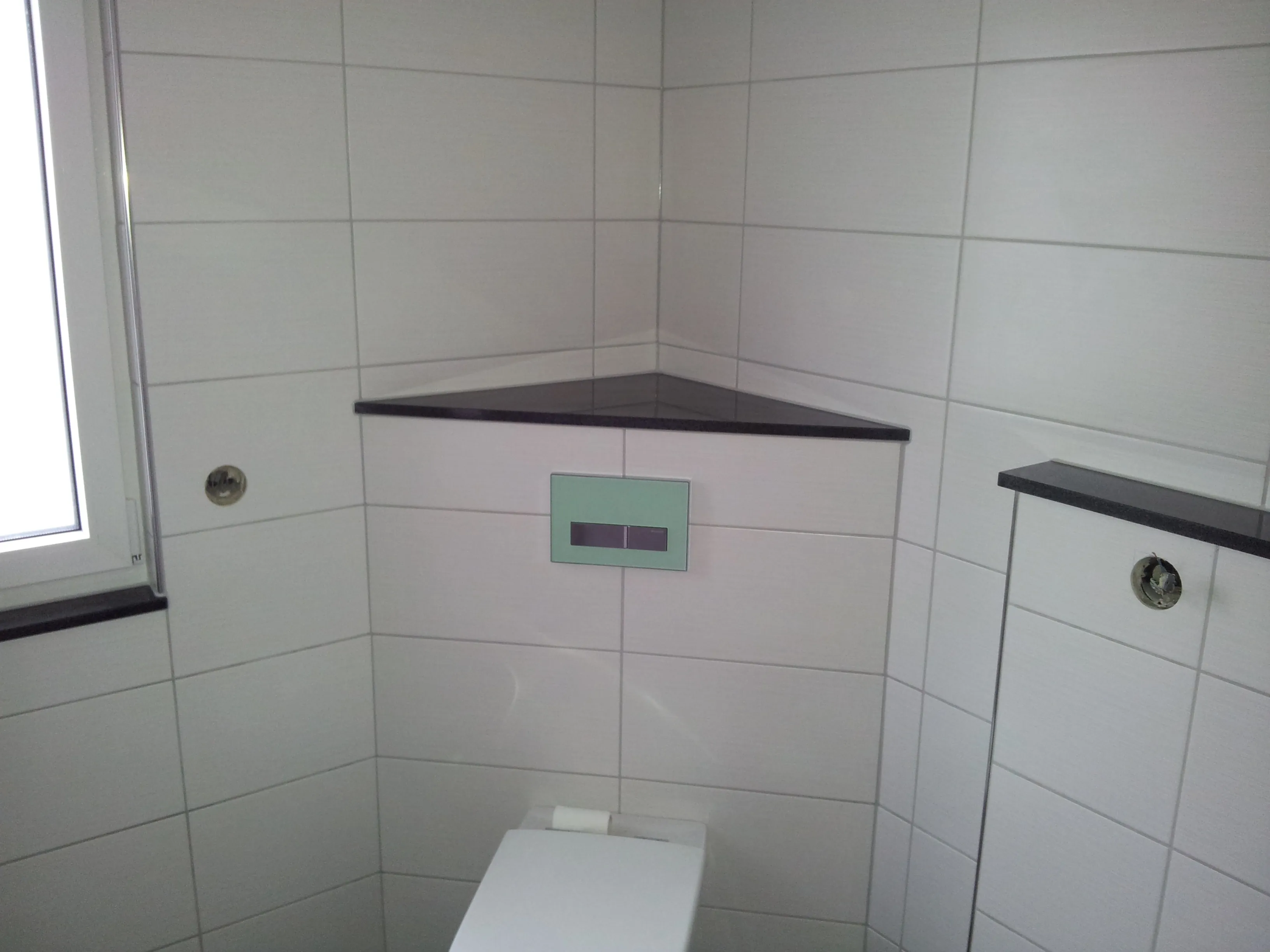 Modernes Badezimmer mit präziser Fliesenverlegung um Sanitärobjekte herum